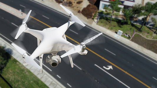 无人驾驶飞机系统 (UAV) Quadcopter 无人机在空中越过道路。