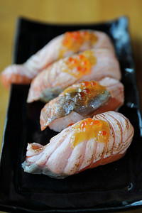 白色黑景摄影照片_在木背景的烤三文鱼寿司