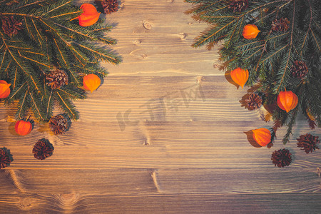 天然材料的圣诞背景 — 圣诞树枝、锥体、木质背景上的酸浆灯笼