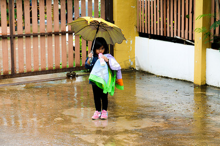 下雨打伞摄影照片_雨中打伞喝牛奶的小女孩