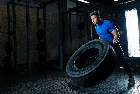 一张强壮的健美运动员在健身房里用重轮的照片