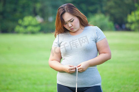 测量她的胃的肥胖妇女