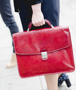 红色公文包摄影照片_年轻成人女商人拿着红色皮革公文包