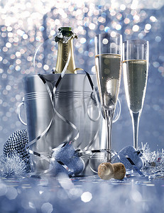 蓝色浪漫背景摄影照片_昏暗的浅白色银色和蓝色浪漫新年前夕或在带香槟的豪华餐厅的圣诞餐桌