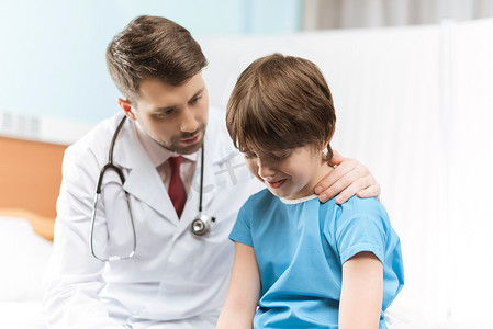 医生在医院为哭泣的小男孩加油打气的肖像