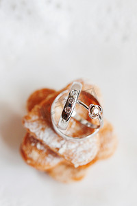 镶有钻石的金色结婚戒指躺在一堆甜饼干上。