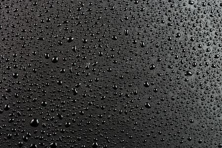 抽象平面黑色疏水表面宏观背景上的水滴