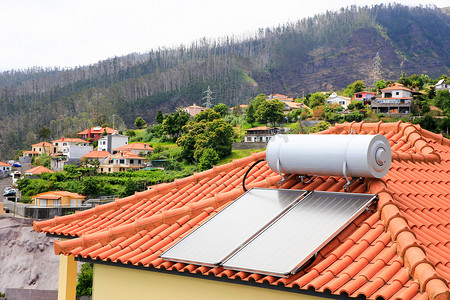 屋顶摄影照片_屋顶有太阳能电池板的热水器