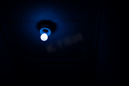 亮色光摄影照片_闪耀在黑暗的屋子里的蓝色光