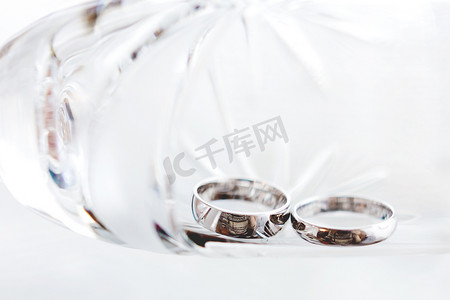 在透明玻璃中的结婚金戒指。