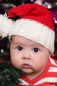 戴着圣诞帽的惊讶新生婴儿的画像
