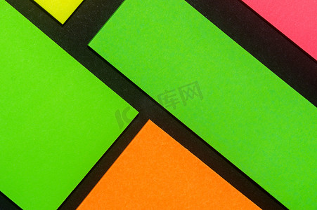 小麻薯贴纸摄影照片_黑纸上的绿色、黄色、橙色和玫瑰色彩色办公室贴纸。 