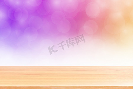 模糊散景柔和紫色渐变背景上的空木桌地板，紫色散景彩色光罩上空的木板，横幅广告产品的彩色散景灯渐变软
