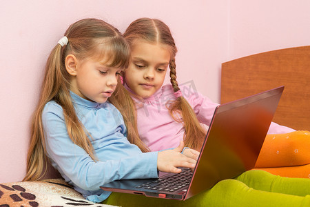 键盘女孩摄影照片_两个女孩在笔记本电脑键盘上推送搜索查询