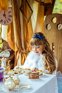 爱丽丝梦游仙境风景中的小美女桌前端着一杯茶的正面图