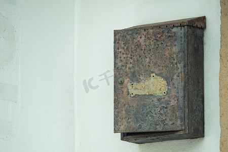 一个生锈的旧邮箱挂在墙上