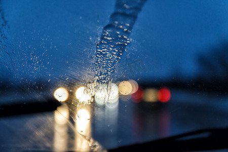公路拍照摄影照片_在雨夜透过汽车的挡风玻璃拍照，