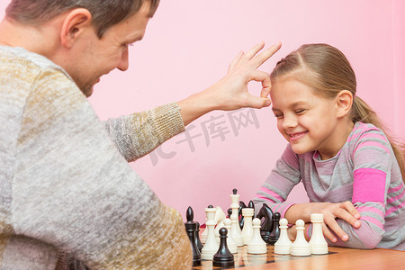 棋格摄影照片_爸爸打赌赢了女儿一盘棋，打了她的头