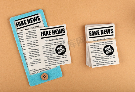 news摄影照片_带有 FAKE NEWS 报纸的毛毡工艺智能手机