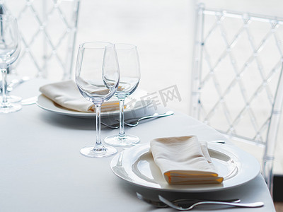 白盘子摄影照片_为宴会提供餐具、酒杯和餐巾的餐桌。