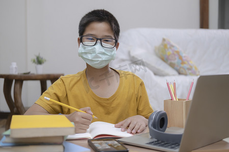 不在线摄影照片_男孩戴口罩在线学习居家降温