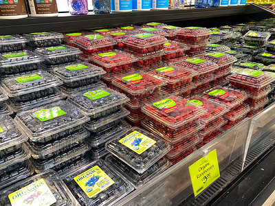 新鲜农产品过道上的覆盆子和蓝莓盒 o