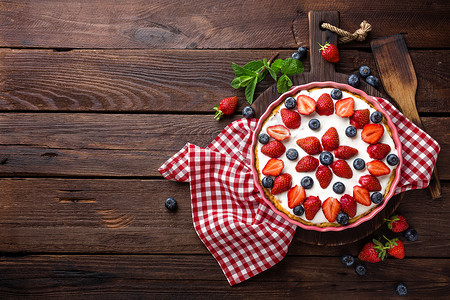 美味的草莓派，配以新鲜蓝莓和生奶油，放在木制质朴的桌子上，芝士蛋糕，俯瞰