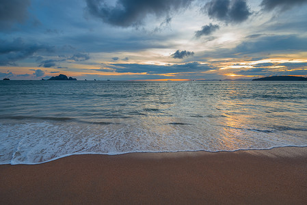 美丽的海浪和沙滩，在地平线上，太阳落山了