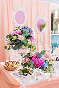花瓶绣球花摄影照片_婚礼宴会用玫瑰和绣球花组成的餐桌。