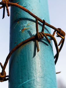 彩绘钢柱和蓝天周围生锈的铁丝网