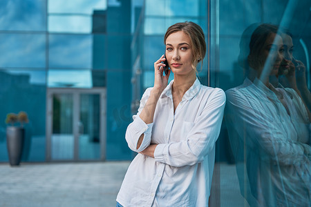 女商人成功的女人商务人士站在户外公司大楼外。