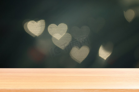 木板在灯光柔和的心形散景上为情人节背景，空木桌地板在心形散景夜光多色背景上，木桌板在散景心形上空