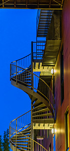 一栋现代建筑的螺旋楼梯，夜间点亮，现代城市建筑
