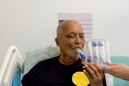 长辈鼓励摄影照片_病人在医院使用激励肺活量计