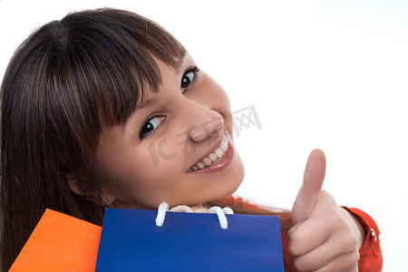 动态问好带字摄影照片_带着彩色袋子购物的微笑女孩表现出好兆头