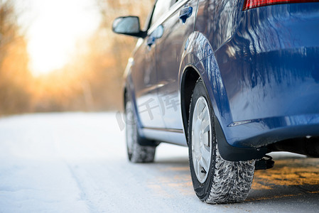 冬季汽车轮胎在雪路上的特写图像。