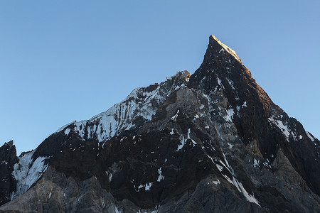 从巴基斯坦 K2 K2 大本营的 Concordia 营地看日落时喀喇昆仑山脉的斜切峰。