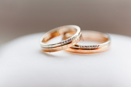 白色背景上镶有钻石的金色结婚戒指。