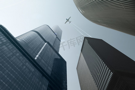 现代摩天大楼和单引擎飞机在蓝色的轨迹