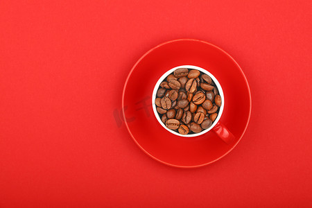 浓缩咖啡杯中的咖啡豆，红色碟子