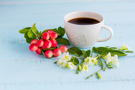 加无奶咖啡、花和水果的白色咖啡杯在木头