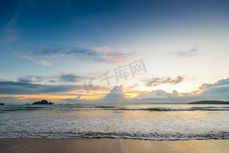 在日落期间，美丽的海浪涌入沙滩