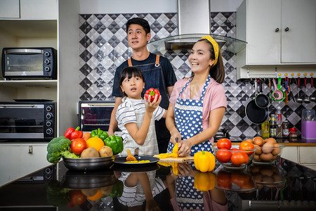 幸福的家庭有爸爸、妈妈和他们的小女儿 Cooking Tog