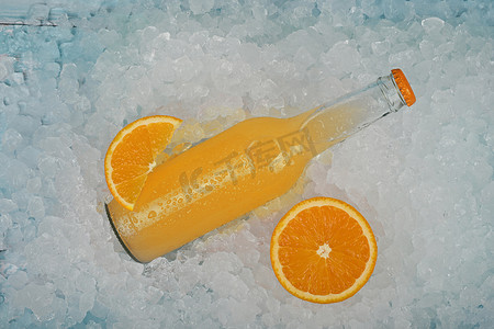 一瓶装在碎冰上的橙汁饮料