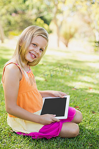 在公园里使用数字平板电脑的年轻女孩