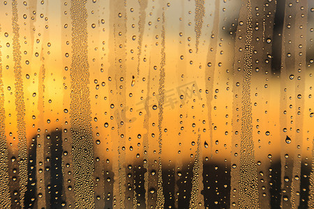 夕阳下的玻璃上的雨