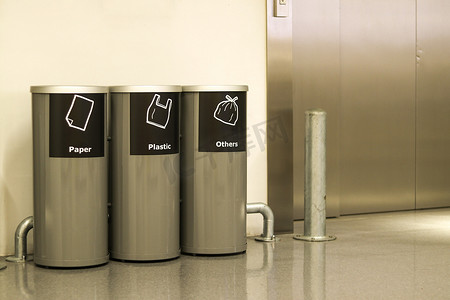 收集徽章摄影照片_乘客电梯前放置了三种用于分离的垃圾箱。