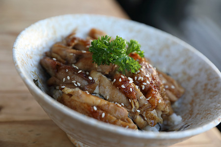 老人烧饭卡通摄影照片_日本食品，木制背景的鸡肉照烧饭