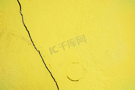 破碎的黄色彩绘混凝土墙。