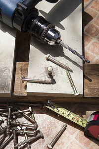 螺丝螺母摄影照片_在木工上用电钻和螺丝螺母 DIY 家庭作业